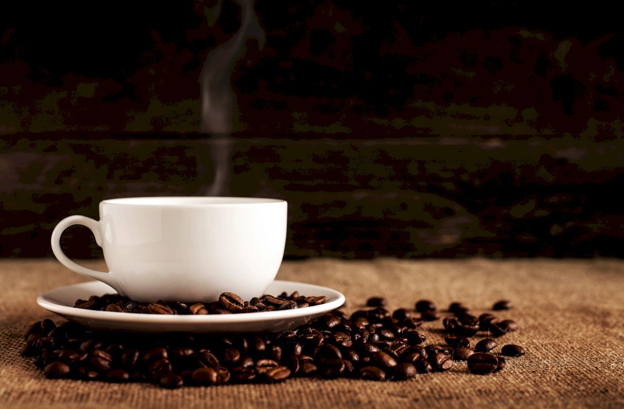 Tinitingnan ang epekto sa carbon footprint sa climate change ng isang tao na may hawak na isang tasa ng kape